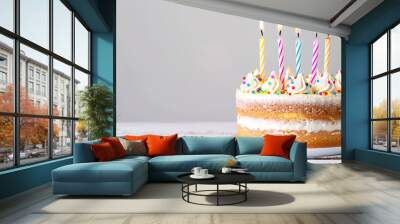 Birthday cake with candles stands on table on white background with copy space.
 Wall mural