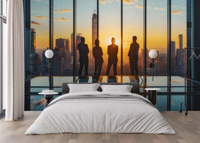 Businessmens look out the window at the big city against the backdrop of sunset. The office has huge windows and lots of sunlight. Wall mural