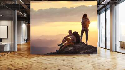 Couple hikers at sunset mountain viewpoint Wall mural