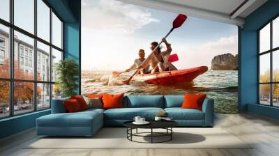 Happy couple walks by sea kayak or canoe at tropical bay Wall mural