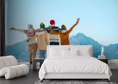 Happy friends embracing against snow capped mountains Wall mural