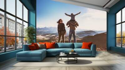 Happy idyllic family against mountains is having fun Wall mural