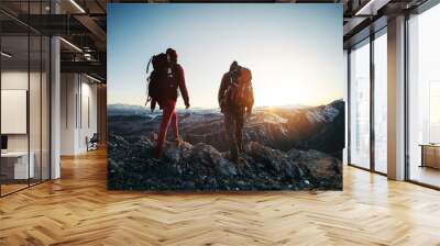 Two hikers walk sunset mountains Wall mural