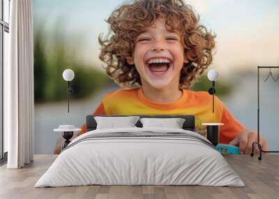 Happy curly boy laughing and holding skateboard, Generative AI Wall mural