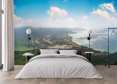 a peaceful Con Dao island, Vietnam, view from Thanh Gia mountain. Coastal view with waves, coastline, clear sky and road, blue sea and mountain. Wall mural