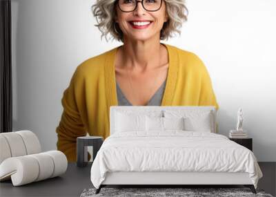 Front view mid shot of a 60-year-old fashionable Caucasian woman dressed in a mustard yellow knit cardigan and black slacks, smiling on a white transparent background Wall mural