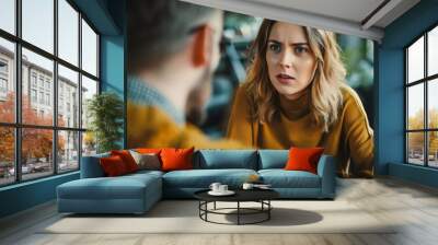 A woman in a yellow sweater is talking to a man in a checkered shirt Wall mural