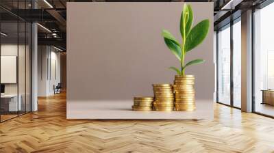 Emerald Growth Amidst Golden Prosperity, a vibrant green plant emerges from a pile of gold coins, symbolizing the flourishing of wealth and investment potential on a clean backdrop. Wall mural