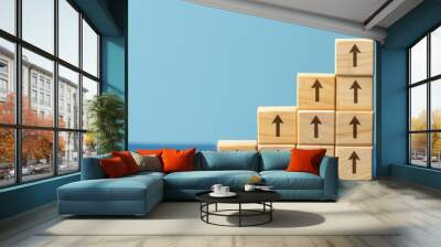 Wooden blocks arranged with upward arrow icons representing gradual improvement, step-by-step progress, conveying a sense of growth and achievement through each level. Wall mural