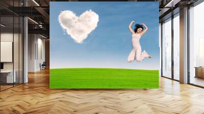 asian girl jumping on green field Wall mural