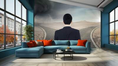 confused businessman looking at two street Wall mural