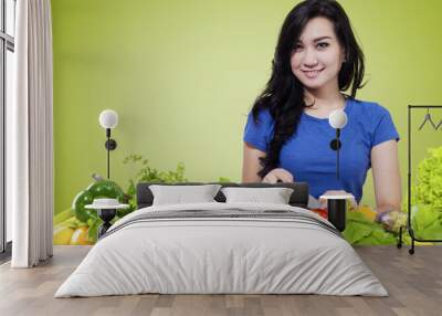 Cute woman preparing organic vegetables Wall mural