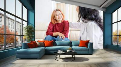 Female psychologist gives solution to female teenager patient in a clinic Wall mural