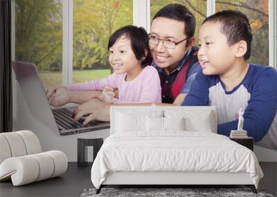 Happy children playing laptop with dad Wall mural