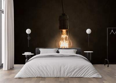 Incandescent light bulb hangs in the dark room Wall mural