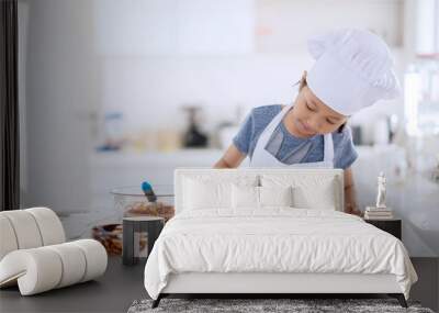 Little chef pouring chocolate dough on the mold Wall mural