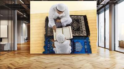 Little son and father reading Quran together Wall mural