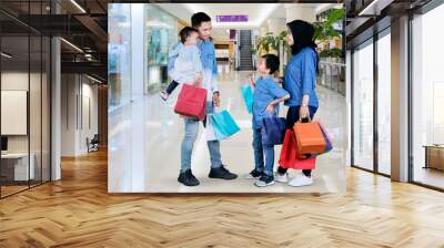 Muslim family with shopping bags in the mall Wall mural