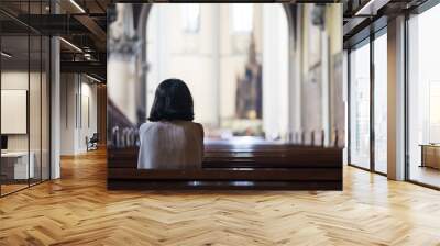 Rear view of devout woman praying in the church Wall mural