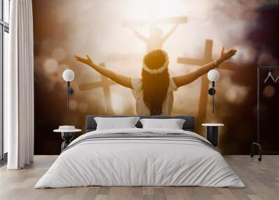 Woman praying to God with shining three crucifixes Wall mural