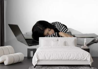 Woman sleeps on bed with laptop and books Wall mural