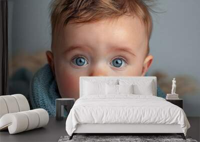 A baby with blue eyes and a blue scarf around its neck Wall mural