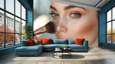 Close-up of a makeup brush applying highlighter to a woman's cheek. Wall mural