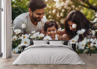 Happy Indian family with a child enjoying a peaceful moment surrounded by white flowers in a lush garden. Wall mural