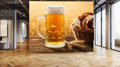 Beer mug with fresh beer and pretzels on wooden table highlighting snacks and drinks Wall mural