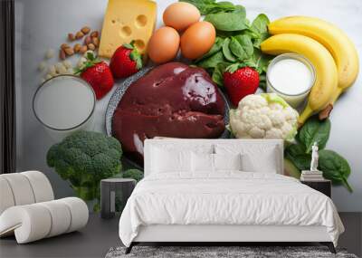 Healthy food ingredients featuring eggs cheese bananas strawberries broccoli and biotin liver on a marble surface Wall mural