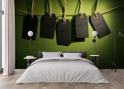 Sale tags hanging on string with discount labels on green background Wall mural