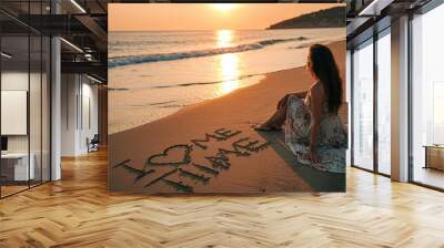 Woman on beach practicing self-love with message in sand at sunset Wall mural