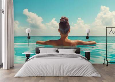 A woman looking at the blue horizon from the pool. Summer relaxation concept. Wall mural