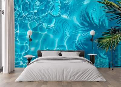 Above view of clear blue swimming pool water and palm tree making shadows on it. Can be used as summer background. Wall mural