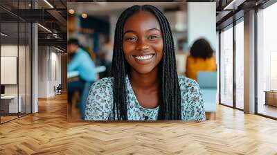 Confident young African American woman smiling at coworking space. Young female professional radiating positivity at work. Wall mural