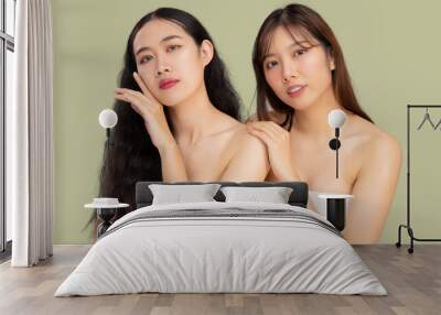 Young pretty asian girls LGBTQ+ lesbian couple clean natural face skin care concept posing looking camera green pastel color background. Beauty and spa. Wall mural