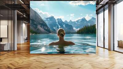 A woman soaks in the serene waters of a mountain lake Wall mural