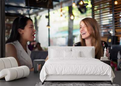 Female friends having a talk in a restaurant Wall mural