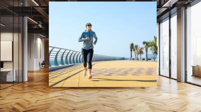 Girl running on the boardwalk by the sea Wall mural