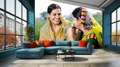 Two happy indian rural women talking on agricultural field Wall mural