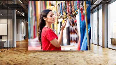 Two women shopping for necklace and earrings at street market Wall mural