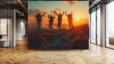 A group of four people are jumping in the air in front of a sunset Wall mural