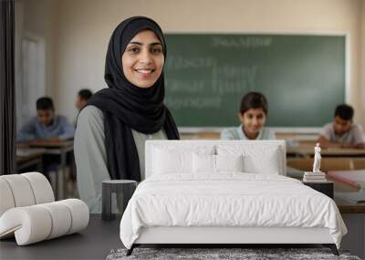 Happy Muslim woman teacher wearing hijab is standing in school classroom with children. Arabic woman and school education Wall mural