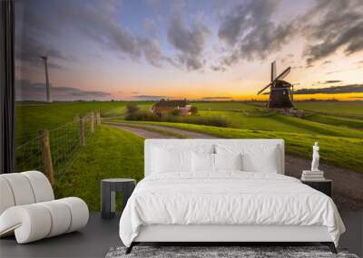 Historic windmill in grassy dairy landscape Wall mural