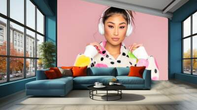 young Asian girl wearing a fashion jacket and music headphones with colorful theme Wall mural