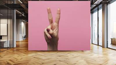 female hands showing number two as part of date of new year 2020, sign language on a colored pink background Wall mural