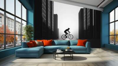 A silhouette of a cyclist riding through an empty street at dawn, framed by tall buildings cyclist, urban, monochrome silhouette Wall mural