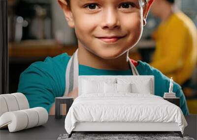 Boy smiling wearing apron pointing finger at viewer Wall mural