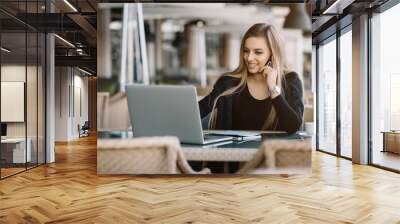 Young beautiful girl preparing for exams with laptop, surfing articles about innovations in web development, programming and design. Business lady working through internet in digital marketing field. Wall mural