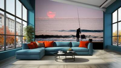 man fishing in the sea with the sun in the background Wall mural